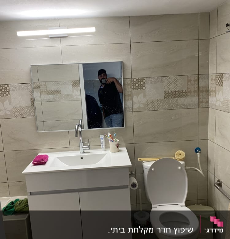 חדר אמבטיה עם כיור חדש ומראה מותקנת